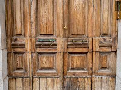 Per farlo varchiamo un portone in legno che presenta dei fasci littori vicino alle maniglie: ricordano come lo stabile fu costruito durante il Ventennio
